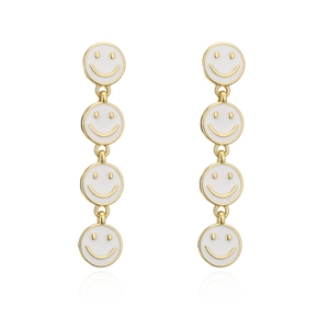 Golden long drop earrings featuring white enamel smiley faces in a minimalist style
