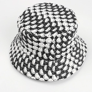 Vue détaillée du dessus d'un chapeau bob réversible avec motifs imprimés smiley noir et blanc