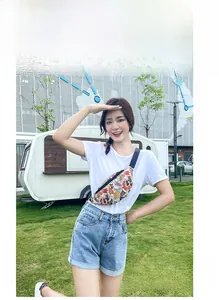 Outdoor shot showing the printed crossbody chest bag with colorful sneaker graffiti pattern