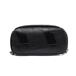 Detailed close-up of geometric leather stitching and texture on the black commuter backpack