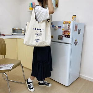 Détail d'un sac cabas en toile blanche avec texte Lovable bleu et motif de lapin