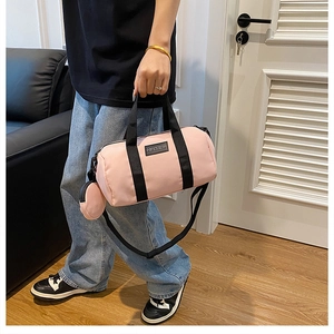 Pink nylon Boston bag detail showing the QIANNING logo and matching round accessory pouch