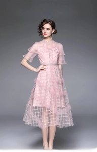 Détail de la robe rose de luxe avec broderie de fil doré et ourlet en tulle à plusieurs niveaux