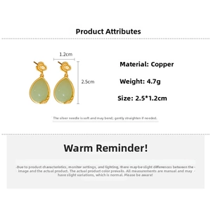 Detailed view of vintage gold water-drop earrings with green resin and silver needles