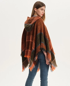 Detail view of hooded knit poncho showing orange plaid pattern and fringed hemline