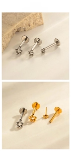 Macro shot of G23 titanium bead flower labret studs in silver and gold finishes