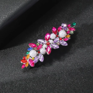 Vue détaillée d'une pince à cheveux avec strass multicolores et perles sur fond noir