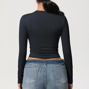 Vue arrière du crop top de sport noir à manches longues avec col rond minimaliste
