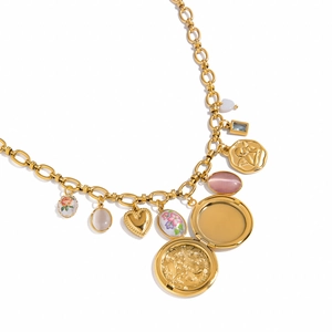 Detail van een gelaagde gouden ketting met een openslaand rond medaillon en florale hangers