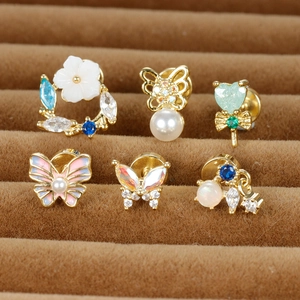 Détail de six boucles d'oreilles avec fleurs et papillons dans un coffret en velours
