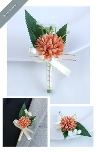 Detail of dusty orange groom boutonniere with green leaves and gold-edged white ribbon