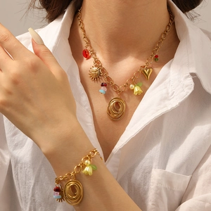 Detail of colorful beaded necklace and bracelet set with lily of the valley floral charms