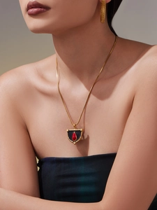 Détail du collier plaqué or 18k avec émail noir et pendentif en pierre rouge