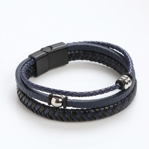 Detail of multi-layer blue and black braided leather bracelet with black magnetic clasp