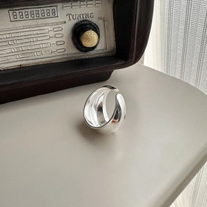 Minimalist S925 sterling silver wide open ring shown in a stylish indoor setting