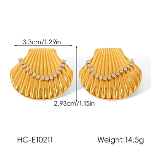 Detailed view of 18k gold scallop earrings with stripes and embedded white zircon stones