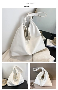 Detail of white minimalist soft leather hobo bag with a decorative shoulder strap knot