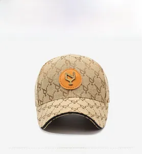 Detailed front view of khaki canvas baseball cap with monogram print and metal logo patch