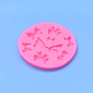 Macro view of a pink silicone mold with various bow and ribbon shapes for fondant or resin