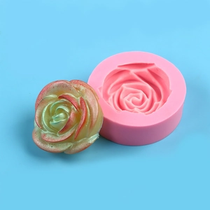 Detail of pink silicone 3D peony mold and a finished yellow-green floral candle