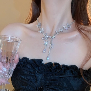 Macro shot of silver butterfly tassel necklace with sparkling zircon on a female model