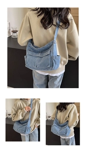 Detail view of denim crossbody bag with dual front flap pockets and workwear style