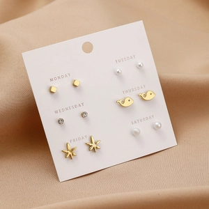 6-pair set of gold-toned pearl and rhinestone stud earrings on a weekly card display