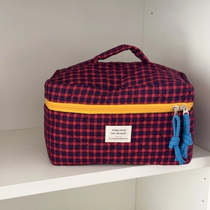 Portable quilted plaid toiletry bag with red and blue checkered pattern and yellow zipper