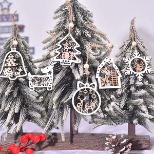 Wooden cutout Christmas ornaments featuring deer and trees on a snowy pine branch