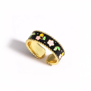 Detail of red enamel flower ring with golden beaded edges and floral patterns