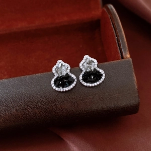 Macro view of sterling silver hulu stud earrings with black and white zircon crystals