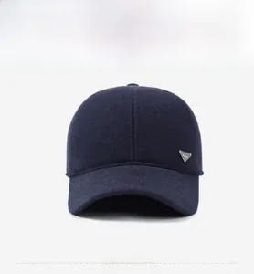 Close-up of dark blue winter baseball cap with thick wool texture and silver metal logo