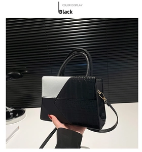 Détail du sac à main bicolore noir et blanc avec une élégante texture crocodile