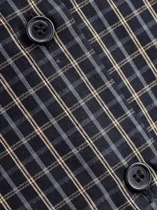 Vue macro de la texture du tissu à carreaux avec boutons noirs sur chemise décontractée