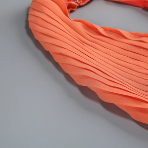 Dettaglio del tessuto in chiffon plissettato ad alta densità arancione vivace