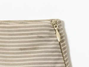 Détail de la texture en coton à rayures beige avec une fermeture éclair invisible