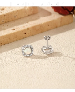 Macro detail of S925 silver stud earrings featuring white opal and zircon halo setting