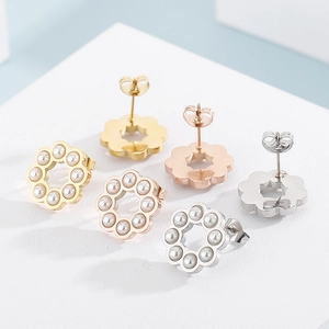 Tre paia di orecchini a perno a fiore in finiture oro, oro rosa e argento