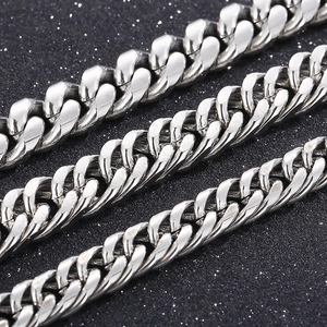 Macro detail of silver stainless steel Cuban link chains with polished finish and tight weave