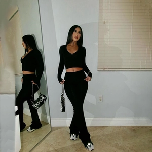 Women's chic black two-piece set featuring V-neck long sleeve top and flared trousers