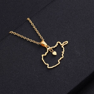 Détail d'un pendentif carte de l'Afghanistan doré avec un petit cœur sur une chaîne