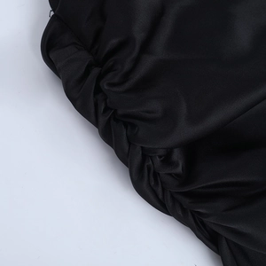 Detail of ruched black satin fabric with silky texture on sleeveless mini dress