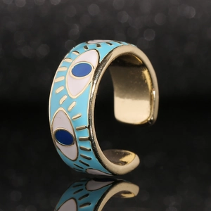 Macro shot of adjustable gold-plated evil eye ring with blue enamel detailing