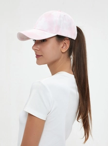 Detail of pink and white tie-dye cotton baseball cap with ponytail style on a model
