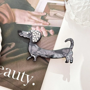 Macro shot of dachshund hair clip with marble acetate texture and rhinestone details