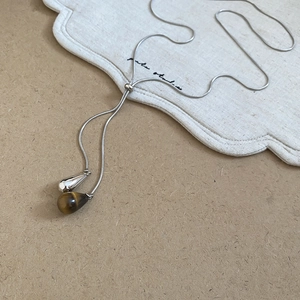 Detail view of silver snake chain with adjustable bead and tiger eye teardrop pendant
