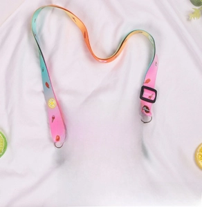 Detail of mint green donut silicone purse with rainbow print and colorful shoulder strap