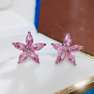 Macro shot of pink zircon flower stud earrings in a luxury jewelry display box