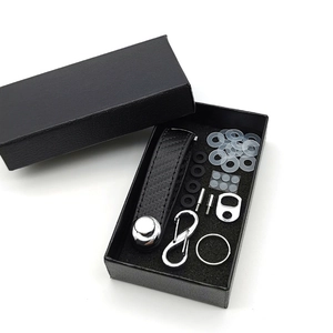 Carbon fiber key organizer kit with metal accessories and bottle opener in a black box