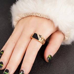 Macro detail of a wide gold ring with black enamel and micro-set zircon geometric patterns